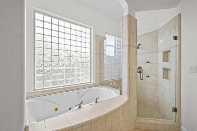 full bath featuring a whirlpool tub, a healthy amount of sunlight, and a shower stall