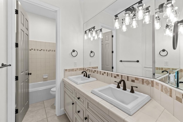 full bathroom featuring tile patterned floors, double vanity, a bathtub, and a sink