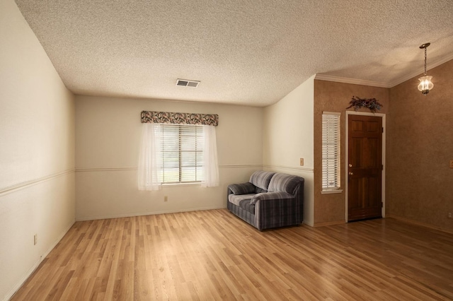 unfurnished room with visible vents, baseboards, a textured ceiling, and light wood finished floors