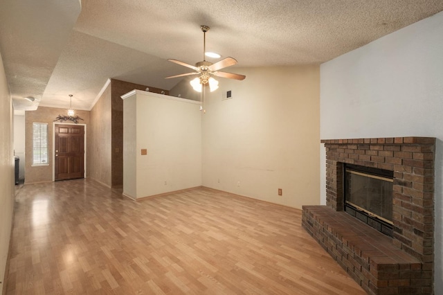 unfurnished living room featuring vaulted ceiling, light wood-style flooring, a brick fireplace, and visible vents