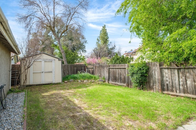 view of yard with an outdoor structure, a fenced backyard, and a shed