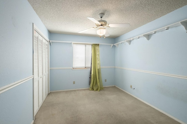 unfurnished bedroom featuring a closet, a textured ceiling, ceiling fan, and carpet flooring