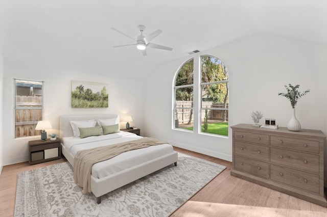 bedroom with lofted ceiling, light wood-style flooring, visible vents, and ceiling fan