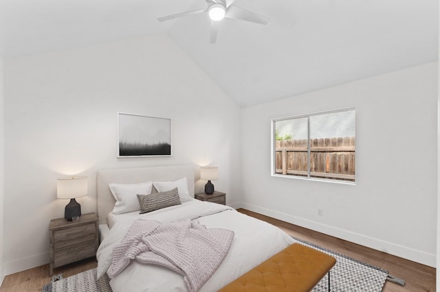 bedroom featuring vaulted ceiling, a ceiling fan, baseboards, and wood finished floors