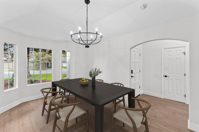 dining space featuring a notable chandelier, baseboards, and light wood-type flooring