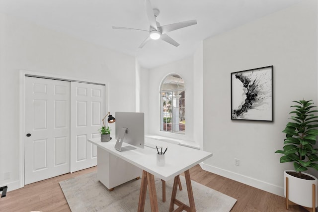 office space featuring baseboards, light wood-style flooring, and a ceiling fan