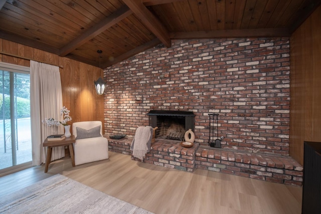 sitting room featuring wood walls, wood ceiling, lofted ceiling with beams, a fireplace, and wood finished floors