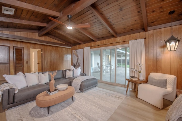 living room with light wood finished floors, visible vents, wood walls, and wood ceiling