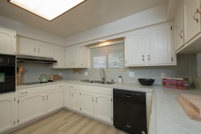 kitchen with a sink, decorative backsplash, black appliances, light countertops, and under cabinet range hood