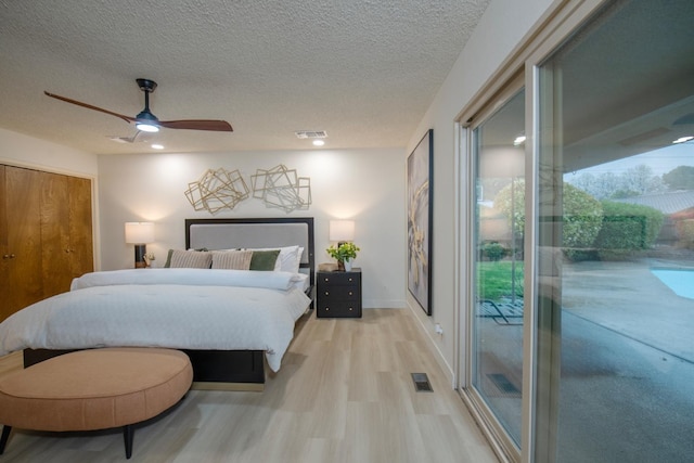 bedroom with access to outside, light wood-style flooring, visible vents, and a textured ceiling