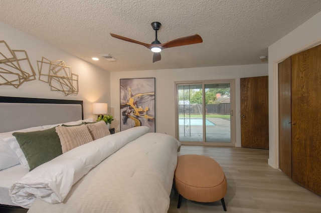 bedroom featuring a ceiling fan, visible vents, light wood finished floors, a textured ceiling, and access to outside