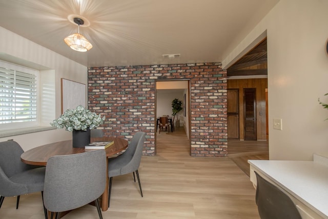 dining area with light wood-type flooring and visible vents