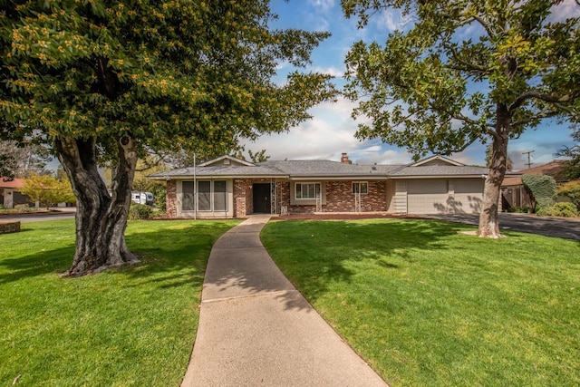 single story home with brick siding, a chimney, a front lawn, and a garage