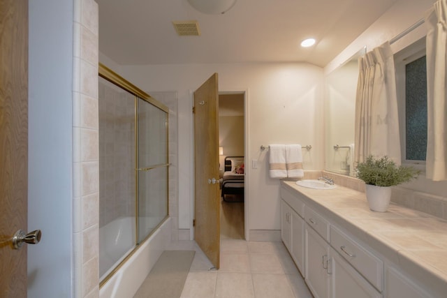 bathroom featuring vanity, visible vents, shower / bath combination with glass door, tile patterned flooring, and ensuite bathroom