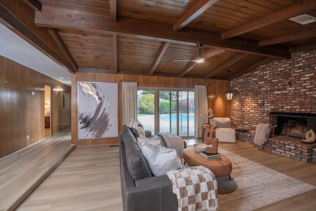 living area featuring light wood-style flooring, wood walls, and lofted ceiling with beams