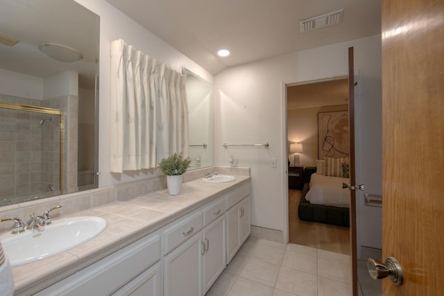 bathroom featuring tile patterned floors, visible vents, a tile shower, and a sink