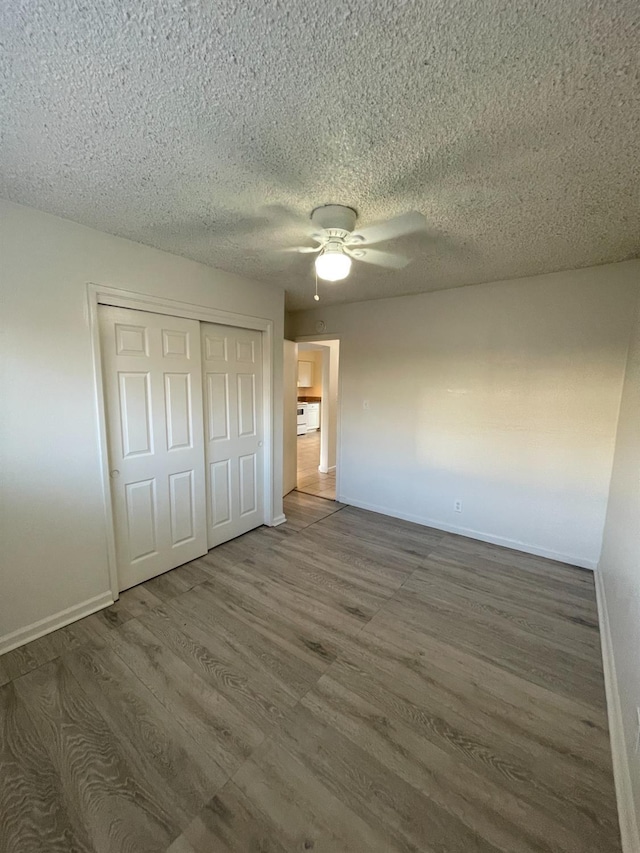4421 E Hedges Ave, Fresno, CA 93703 - unfurnished bedroom featuring baseboards, wood finished floors, a textured ceiling, and a closet