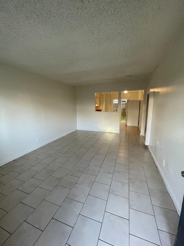 4421 E Hedges Ave, Fresno, CA 93703 - unfurnished room featuring a textured ceiling and light tile patterned floors