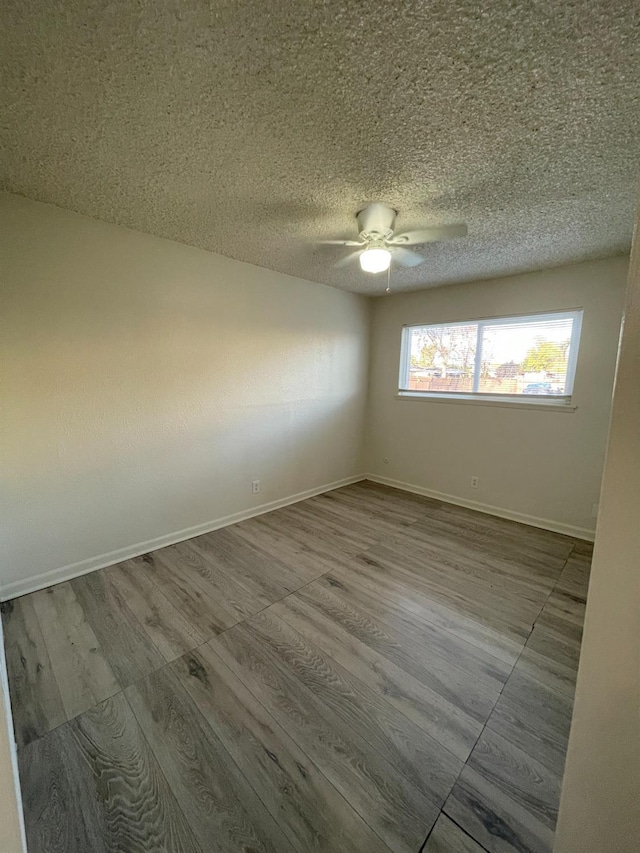 4421 E Hedges Ave, Fresno, CA 93703 - unfurnished room featuring a textured ceiling, wood finished floors, a ceiling fan, and baseboards