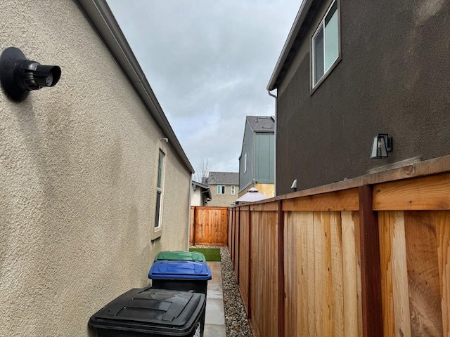 view of home's exterior with stucco siding and fence