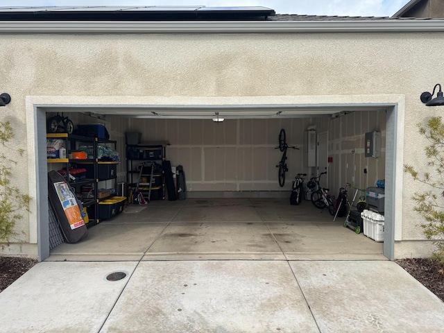 garage featuring electric panel and driveway