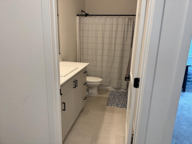 bathroom featuring curtained shower, toilet, vanity, and tile patterned flooring