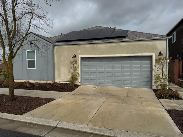 view of front of home with stucco siding, concrete driveway, and a garage