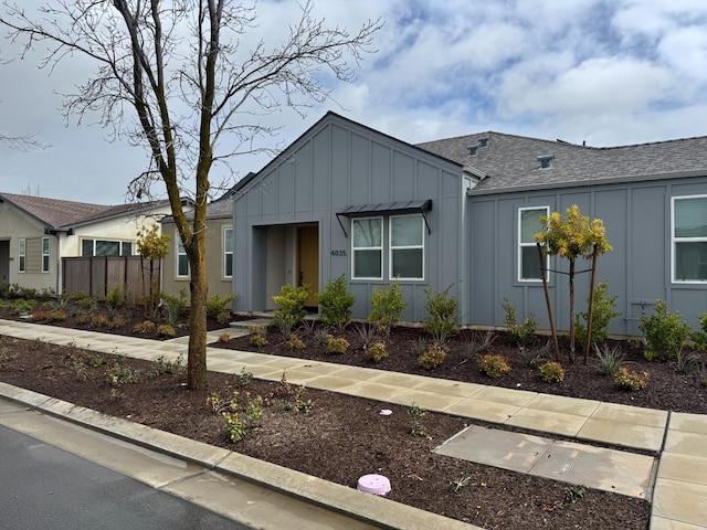 view of front of house featuring board and batten siding and fence