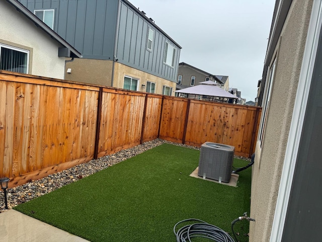 view of yard featuring a fenced backyard and central AC