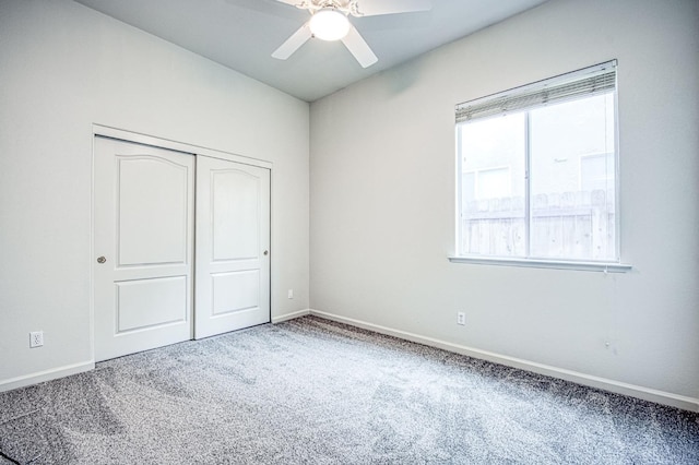 unfurnished bedroom with a closet, a ceiling fan, baseboards, and carpet floors