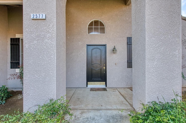 view of exterior entry featuring stucco siding