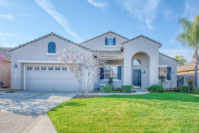 mediterranean / spanish house with a front lawn, a tiled roof, stucco siding, a garage, and driveway