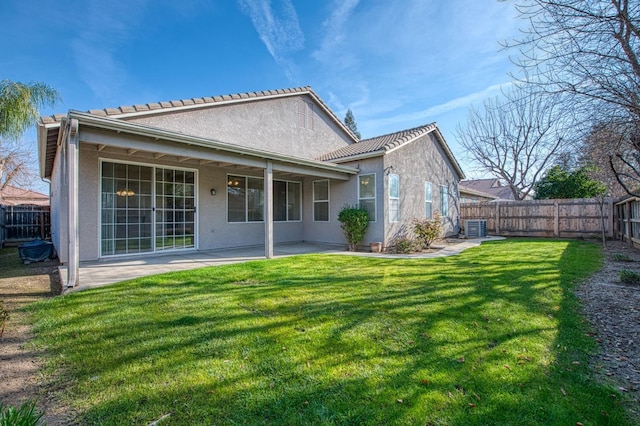 rear view of property with a yard, fence private yard, and stucco siding