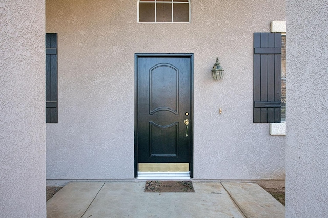 view of exterior entry with stucco siding