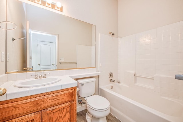 full bath featuring vanity, washtub / shower combination, toilet, and wood finished floors