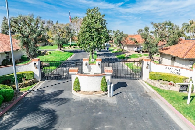 view of road with a gated entry, curbs, and a gate