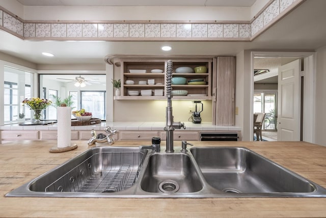 interior space with open shelves, plenty of natural light, a ceiling fan, and light countertops