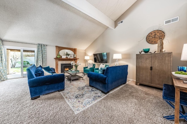 carpeted living room with a tiled fireplace, visible vents, a textured ceiling, and lofted ceiling with beams