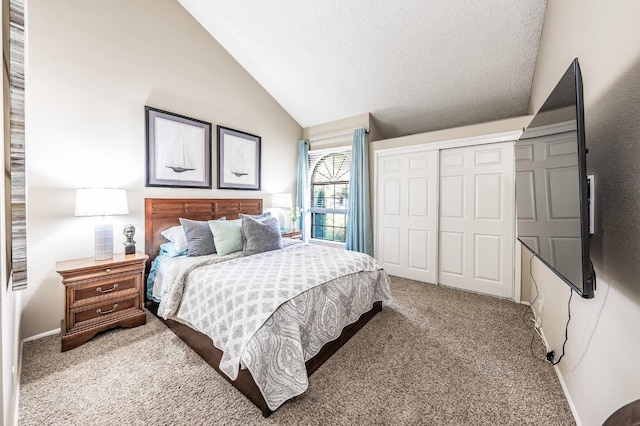 carpeted bedroom with a closet, a textured ceiling, and vaulted ceiling