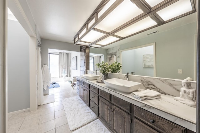 bathroom with tile patterned floors, double vanity, visible vents, and a sink