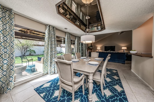 dining area featuring tile patterned flooring, visible vents, a textured ceiling, and baseboards