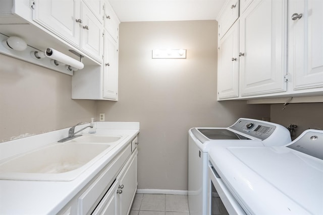 laundry area with baseboards, washer and clothes dryer, light tile patterned floors, cabinet space, and a sink