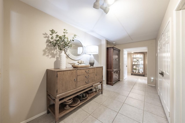 corridor with light tile patterned floors and baseboards