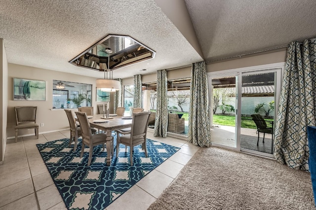 dining area featuring light tile patterned floors, baseboards, and a textured ceiling