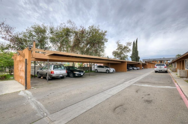 covered parking lot featuring fence