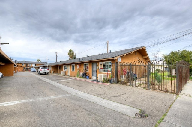 ranch-style home featuring fence and uncovered parking