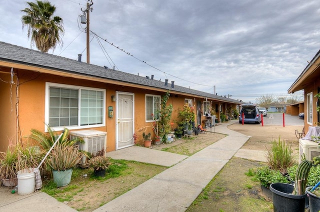 ranch-style home with stucco siding and a shingled roof