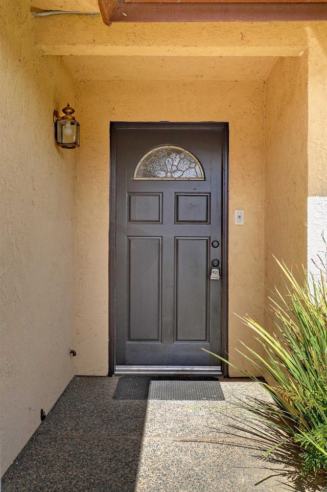 entrance to property featuring stucco siding