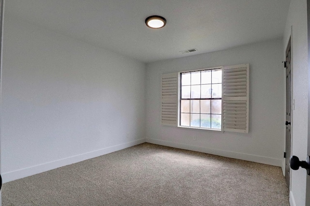 carpeted empty room featuring visible vents and baseboards