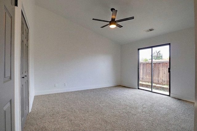 empty room with visible vents, baseboards, ceiling fan, vaulted ceiling, and carpet floors